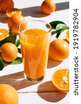 Small photo of Ripe bio oranges and a glass of fresh squeezed orange juice on white wooden background. Organic Sicilian oranges