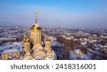 Small photo of Cityscape winter drone photo. Areal view on Cristian church in snowed town suburb. Golden cross on a roof
