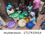 Small photo of Zinder, Niger - September 2013: Beautiful African girls in colorful clothes and turban making traditional sweet cookies from forgo flour in small kitchen local manufacture
