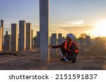 Construction engineers survey checkpoints of concrete pile,  load-bearing piles of the tall building at the construction site evening time.
