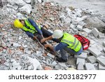 Small photo of Accident in construction workplace, Knee accident from slip or stumble fall on the concrete scrap at construction site. Foreman to helping injured colleague with first aid bag, Unsafe in workplace.