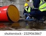 Small photo of Two Officers of Environmental Engineering Wearing Protective Equipment with Masks Inspected Oil Spill Contamination in Warehouse Old, Hazardous Fuel Leakage and Environmental Concept.