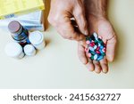 Small photo of Unrecognizable close up handful of pills in his hand, other hand takes one piper from common pile. Prescribed treatment must be performed. Dependence on pills. Vitamins and minerals.