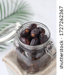 Small photo of Dates fruits in the glass jar with white background. Negatif space. selective focus