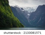 Beautiful Norwegian mountains landscape, in the background the Kjenndal Glacier in Jostedalsbreen National Park. The azure color of the lake's water