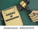 judge's gavel, pen and paper board with the word evidence of wrongdoing. the concept of guilt is proven. concept of evidence 