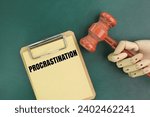 Small photo of judge's gavel and paper board with the word procrastination. the concept of postponement or being postponed