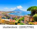 Naples, Italy. View of the Gulf of Naples from the Posillipo hill with Mount Vesuvius far in the background and some pine trees in foreground. August 31, 2021. 