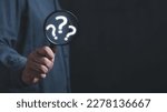 Small photo of The concept of finding an answer to complex questions in business. Hand holding a magnifying glass with question mark.