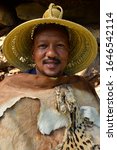 Small photo of Basotho Cultural Village, Golden Gate, Free State, South Africa. March 16 2018. Head tribesman dressed in ceremonial springbok and cheetah skins with traditional woven Basotho grass hat.