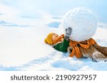 Happy little child boy lying in snow with big snow globe. Happy winter holidays concept. Place for text of positive news, advertising.