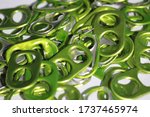 a collection of bright green metallic soda tabs on a white background