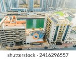 Small photo of Dubai, UAE - May 29, 2019: It is view of Dubai Marina and rooftop of building apartment on promenade. It is Falcon hotel. It is Perl Marina hotel.