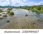 Small photo of Low water in the riverbed of the Pinios, one of the longest rivers in Thessalia, Greece, now dried after heat and drought, potential effect of climate warming, wide landscape blue sky, copy space