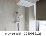 Small photo of Close up shower head in modern bathroom with water drops flowing.Sanitary ware for bathroom interior.Running water of shower faucet.Fresh shower behind wet glass window with water drops splashing.