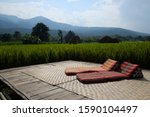 Small photo of Foldout Triangle Thai Cushion on the traditional Thai mat with rice field and mountain in the background.