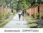 Small photo of Two girls holding hands and walking on the gravel alley in King Mihai I park in Bucharest, Romania.