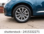 Small photo of Vehicle tire of auto model in firmament blue metallic color parked in urban area. Main purpose of limiting transmission of road vibrations to automobile body