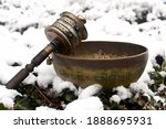 Small photo of A tibetan singing bowl in the snow. Translation of mantras : transform your impure body, speech and mind