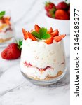 Small photo of Strawberry trifle dessert with custard, cake crumb and fresh strawberry in glass on marble. Recipe of simple layered dessert with fresh berry and jam. Lactose free cheesecake, vegan dessert tiramisu.