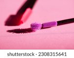 Two silicone mascara brushes pink and violet colors flatly. Pinky and purple lash brushes dynamic photo. Modern decorative cosmetics for women. Female beauty and glamour beautician tools top view.