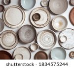 handmade ceramics, empty craft ceramic plates and bowls on light background, top view