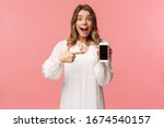 Small photo of Portrait of impressed, excited young blond woman showing something awesome on display, pointing mobile phone screen and smiling astonished, brag with her recent match on dating app