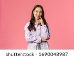 Small photo of Hmm interesting. Portrait of smiling creative girl in denim jacket, thinking, have intriguing idea, smirk and look upper left corner, daydreaming, planning something for party, pink background