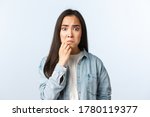 Small photo of Lifestyle, people emotions and beauty concept. Anxious and concerned panicking asian girl grimacing, touching chin, look guilty or nervous, worried someone found out her fault