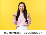 Small photo of Lifestyle, emotions and advertisement concept. Cheerful and excited cute asian girl winning lottery, feel luck and upbeat, triumphing over achievement, say yes and fist pump rejoicing
