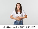 Woman having stomach ache, bending and holding hands on belly, discomfort from menstrual cramps