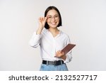 Small photo of Image of young asian business woman, female entrepreneur in glasses, holding tablet and looking professional in glasses, white background