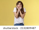 Small photo of Girl panicking feeling scared timid insecure biting fingernails stare camera frightened clench teeth trembling fear touch face nervously feeling unconfident terrified stand yellow background