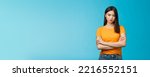 Small photo of Serious-looking confident and arrogant asian woman cross hands chest powerful ignorant pose, look indifferent strict bored face, stand blue background unimpressed, demand answers. Copy space