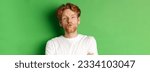 Small photo of Emotions and fashion concept. Silly redhead guy with beard pucker lips and leaning for kiss, standing over green background.
