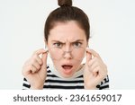 Small photo of Close up of shocked, insulted young woman, frowning and looking offended, reading smth offensive and upsetting, takes off glasses, stands over white background.