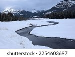 picturesque snowy mountain  and lamar river  scene along the grand loop road in winter in the lamar valley of northeastern yellowstone national park, wyoming