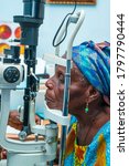 Small photo of image of an old or aged African sitting in front of a slit lamp for eye examination