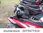 Small photo of A helmet or helm or model, jenis dan mancam helm SNI on a parked bike. November 16, 2021, yogyakarta, Indonesia, helm berwarna hitam diatas jok motor