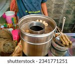 Small photo of Food vendors, Fried satay, kids eat. Indonesia, August 3, 2023, penjual makanan anak anak, cilor, telur gulung, sedang memasak, digoreng dengan minyak di wajan, harga 2k setiap tusuknya, jajanan anak