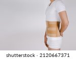 Small photo of Orthopedic lumbar corset on the human body. Back brace, waist support belt for back. Posture Corrector For Back Clavicle Spine. Post-operative Hernia Pregnant and Postnatal Lumbar brace after surgery.