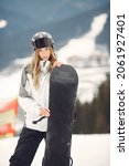 Small photo of Girl snowboarding in the mountains with the snowboard