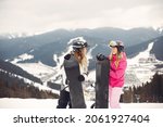 Small photo of Girls snowboarding in the mountains with the snowboard
