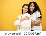 Embrace equity on multiracial Internal Women's Day. Lady diversity group good mood hands hug herself shoulders enjoy joyful soft cloth laundry warmth toothy smile.