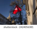 Small photo of National flag of Tunisia. The flag of Tunisia flutters in the wind. The flag of Tunisia hangs on the flagpole. The Tunisian flag at the Tunisian Embassy in Moscow. Close up. Bottom up view.