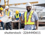 Small photo of Portrait African American engineer man thump up with team working with paper work and precast cement factory background