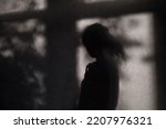 Silhouette of lonely woman at home. Unknown female person shadow on wall. Depression concept.