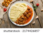 Goulash with beef and carrots with mashed potatoes top view on wooden table