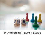 Colorful, bright game chips stand on a game Board with playing cubes: the concept of Board games, the background, games at home, a place for text