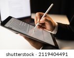 Small photo of Close up businessman hand electronic Signature on Tablet by Stylus. Write business agreement of contract. Man signing contract on tablet. Business and technology concept.